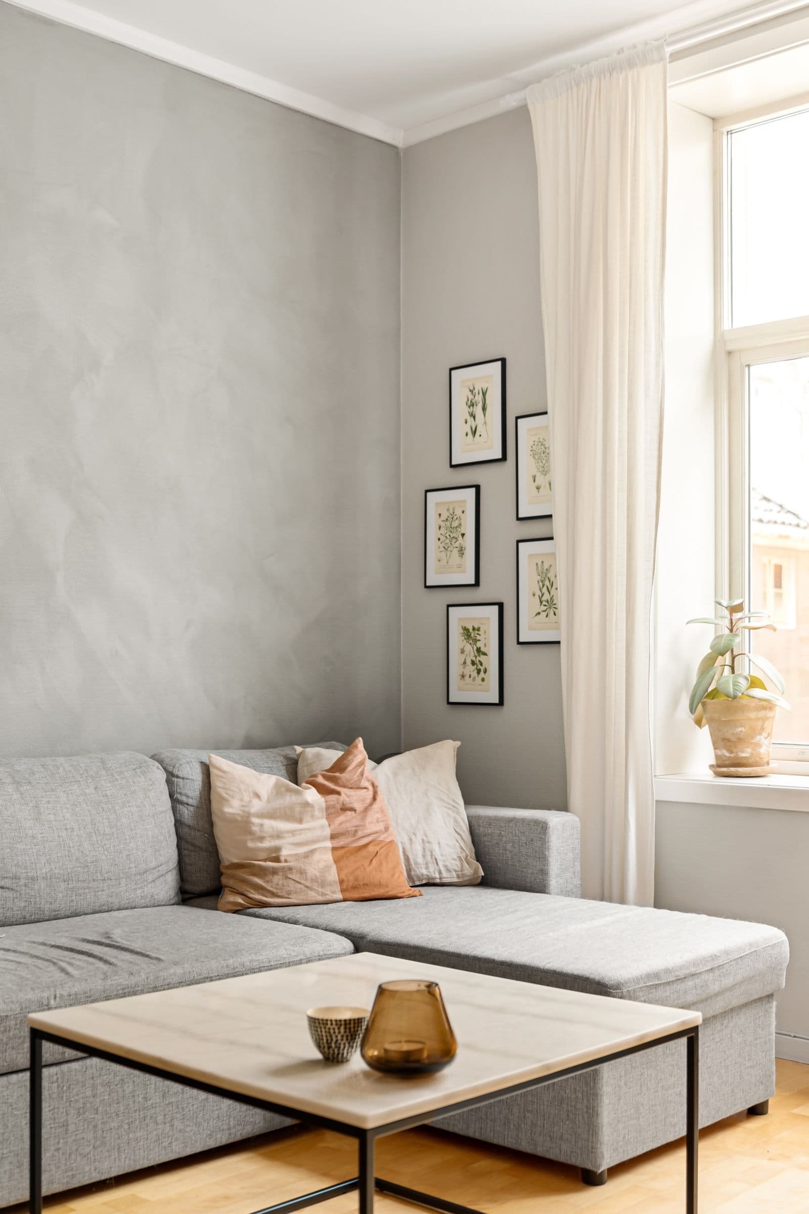 Close-up of a high-end interior with natural linen fabrics, artisanal ceramic vase, and soft morning shadows on a lime-wash wall